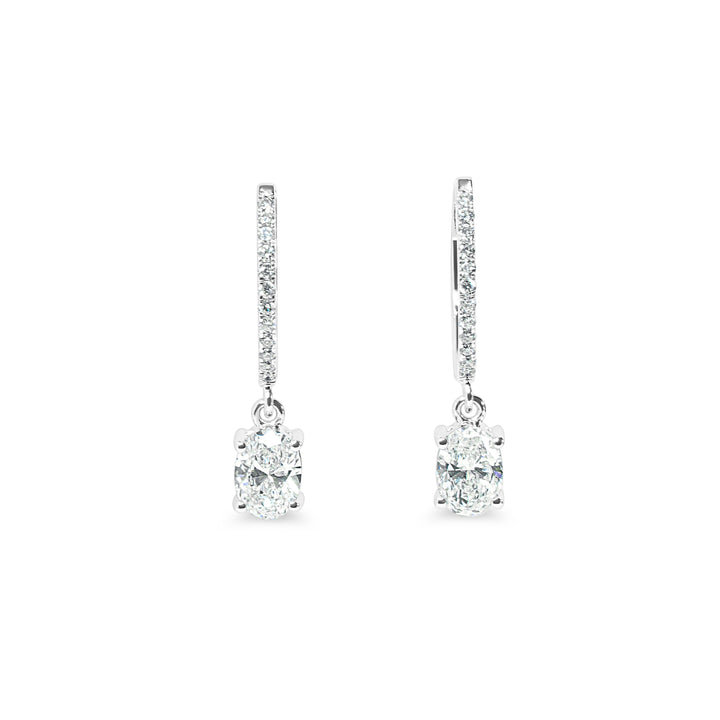 Pair of diamond huggie earrings on a white background