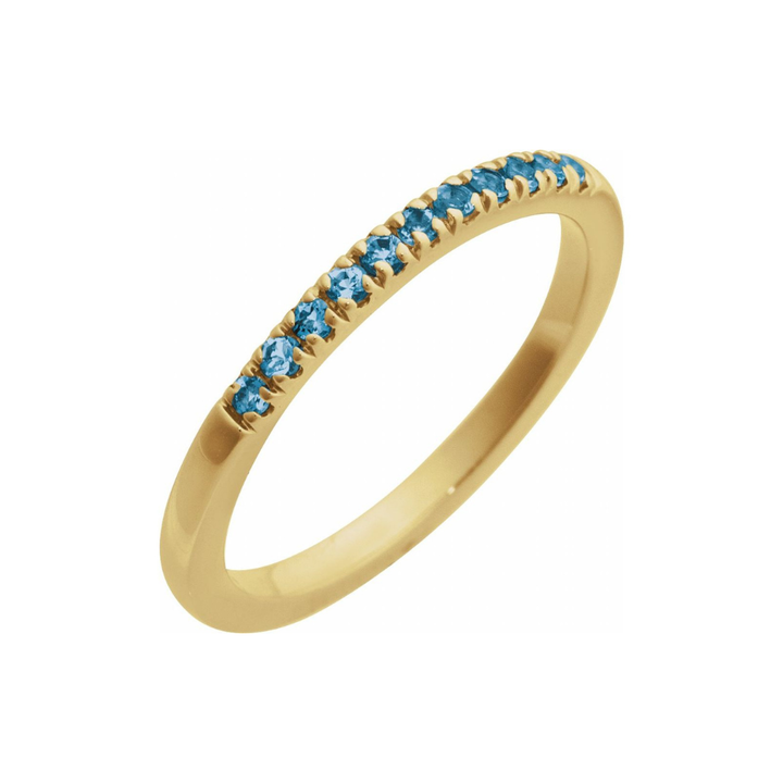 Gold ring with blue london topaz stones on a white background