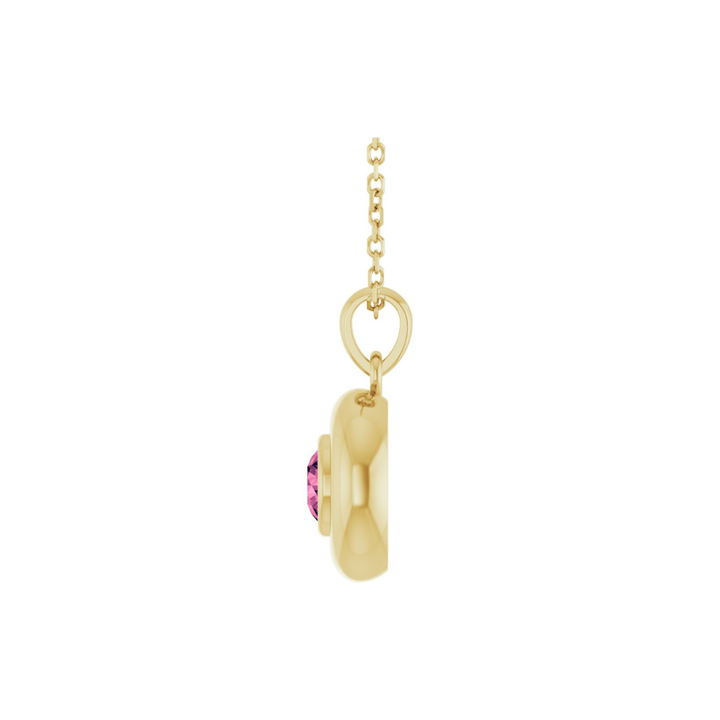 Gold pendant with a pink tourmaline on a white background