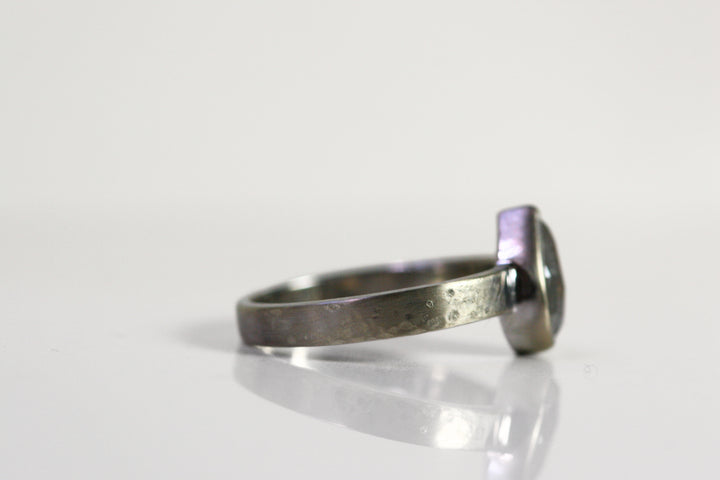 A side view of the ring. The band is the same thickness all the way around and has a hammered finish, adding some interesting texture.