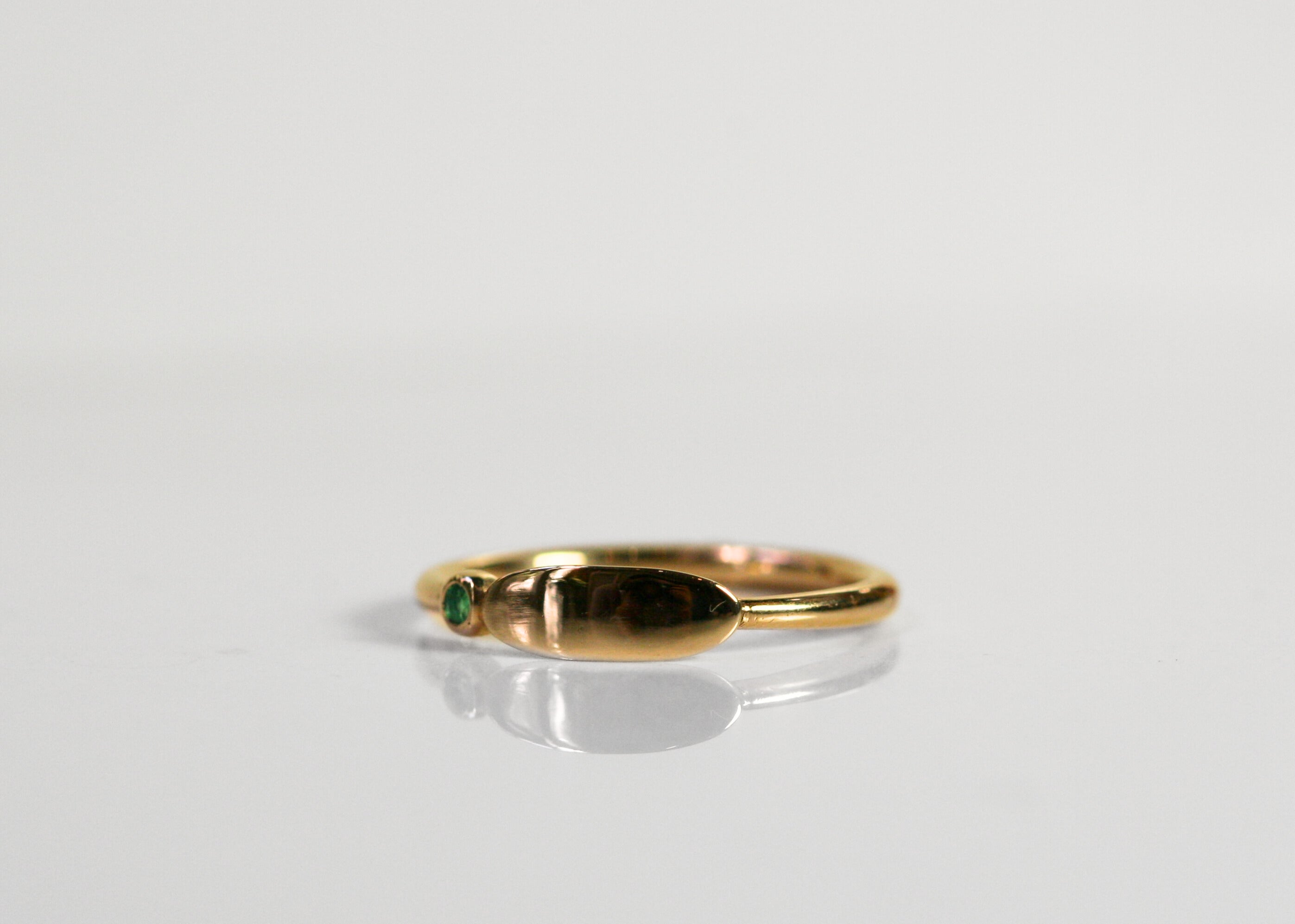 Yellow gold ring - wide oval signet ring. Round emerald is bezel set next to the signet. Face of ring could be engraved!