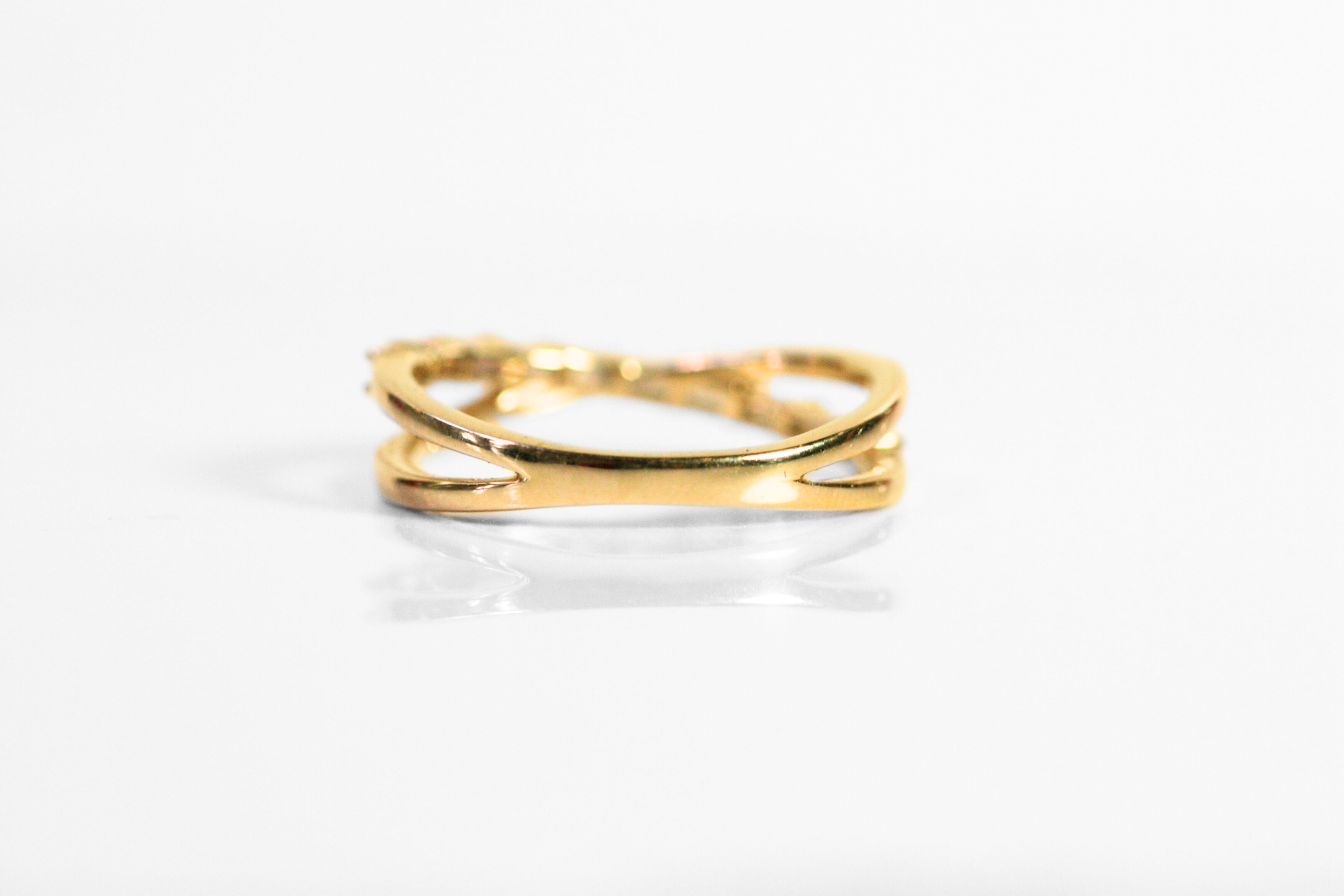 The back of the ring meets in a solid band. This allows the ring to be sized up or down, or can be engraved.