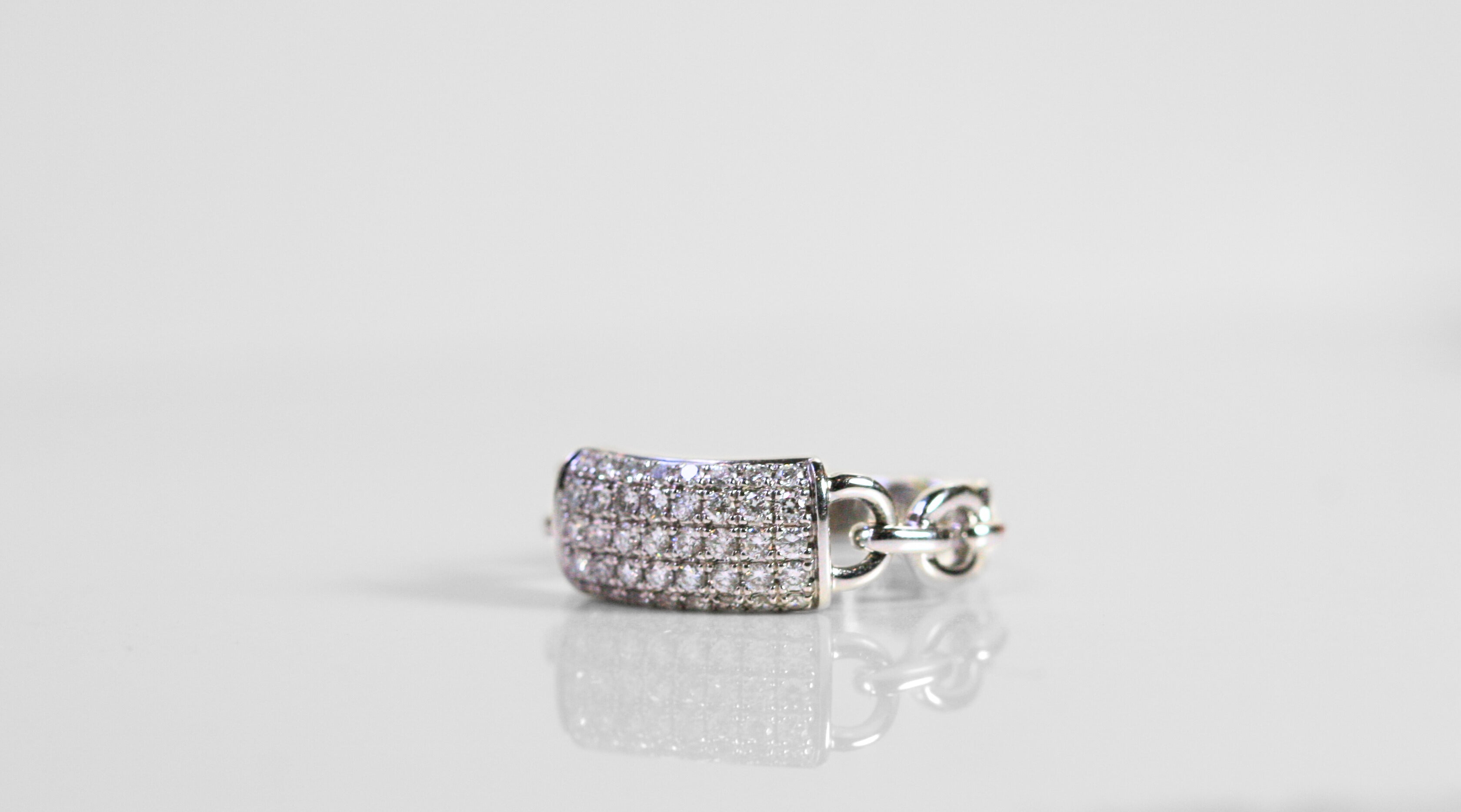 White gold ring. Front of the ring is a rectangle pave set with diamonds. The shank of the ring is a chain of white gold. 