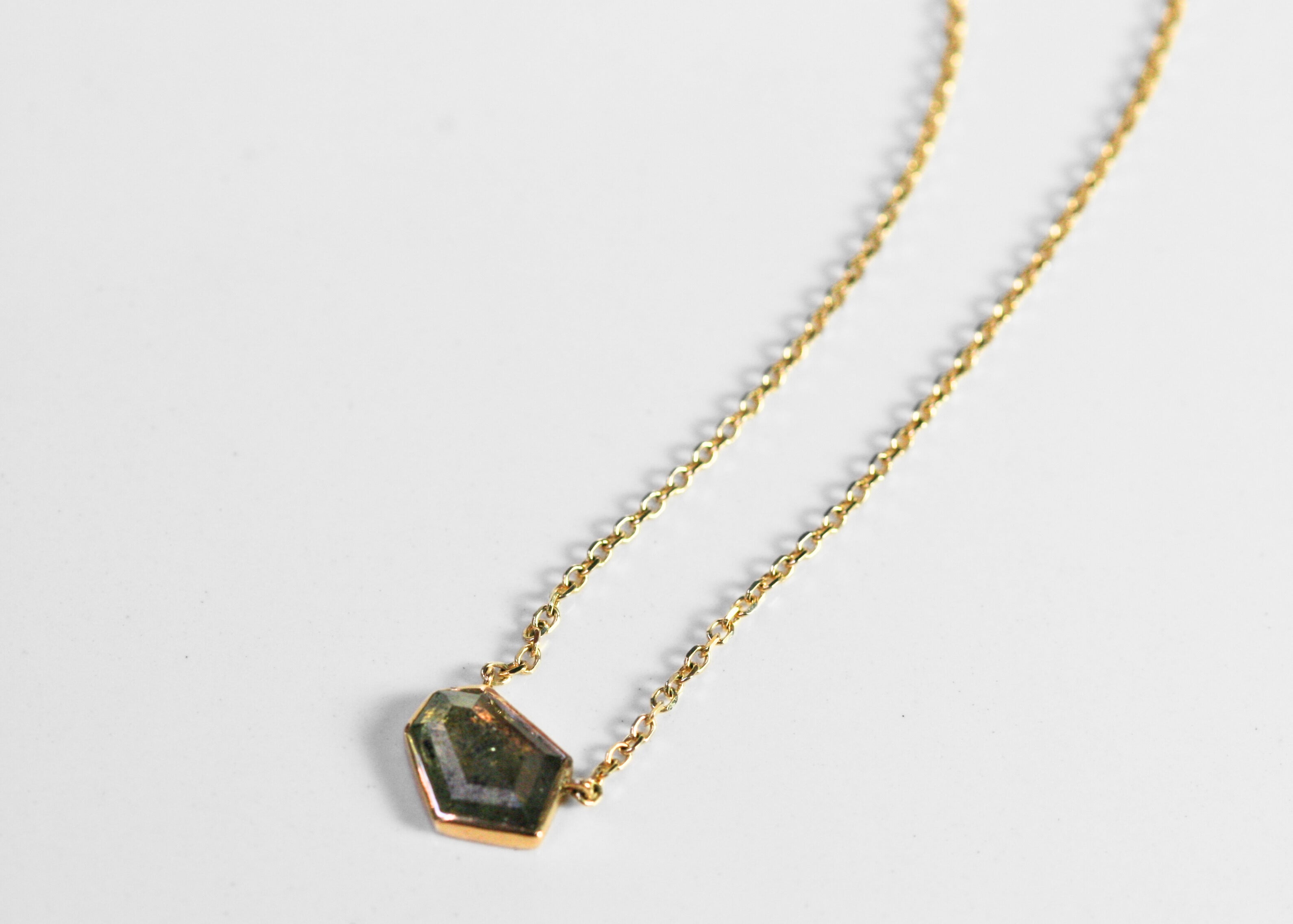 Abstract salt and pepper diamond is bezel set in yellow gold. Pendant, attached to a yellow gold rolo chain. Diamond has interesting inclusions. 