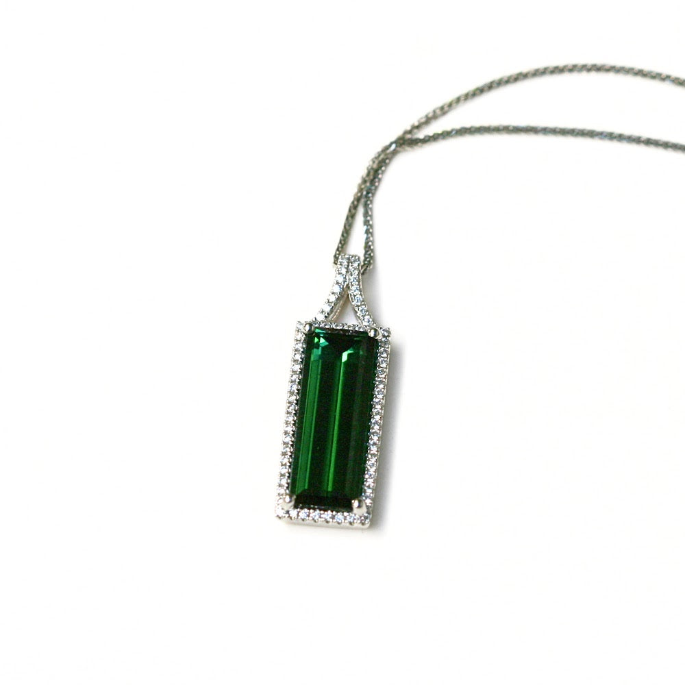 Green rectangle stone. Dark green. Surrounded by diamonds, set in white gold.