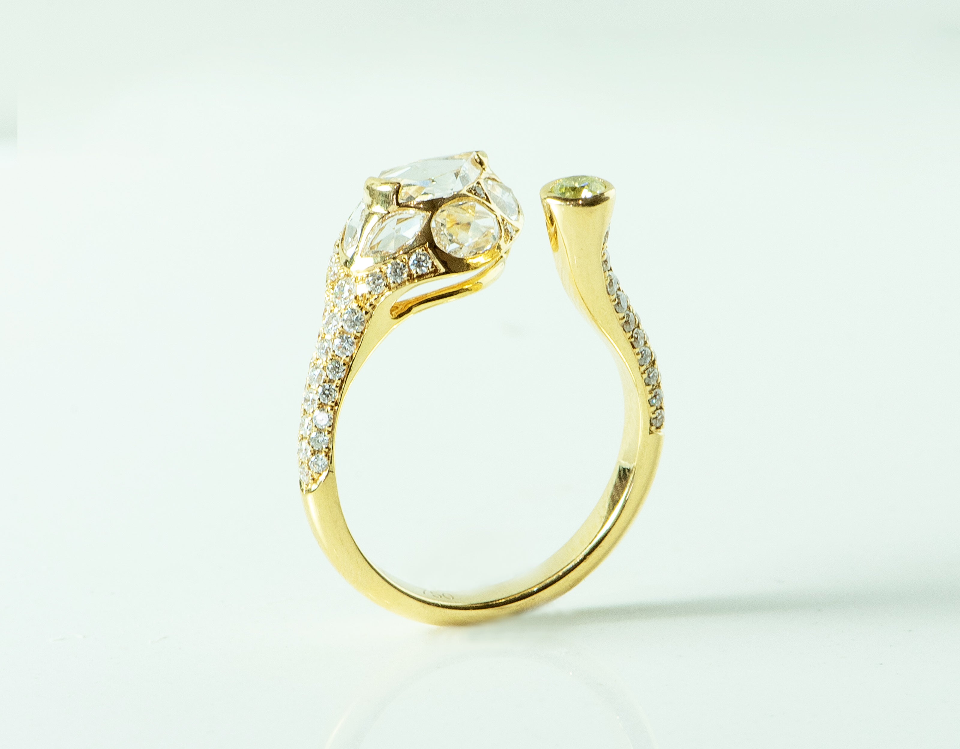 Yellow gold snake ring. With diamonds. Rose cut diamonds on the head and round diamonds on the rest of the ring. There is a yellow diamond set on the "tail".