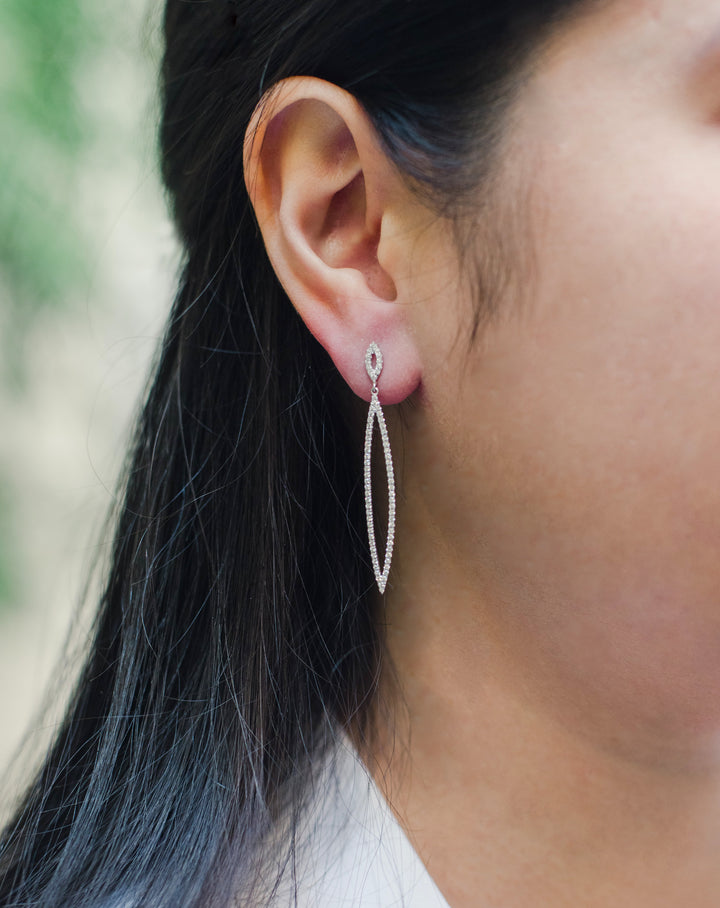 White gold dangle earrings. Diamonds are pave set. Marquise shape - ovals with pointy ends. Have post backings.