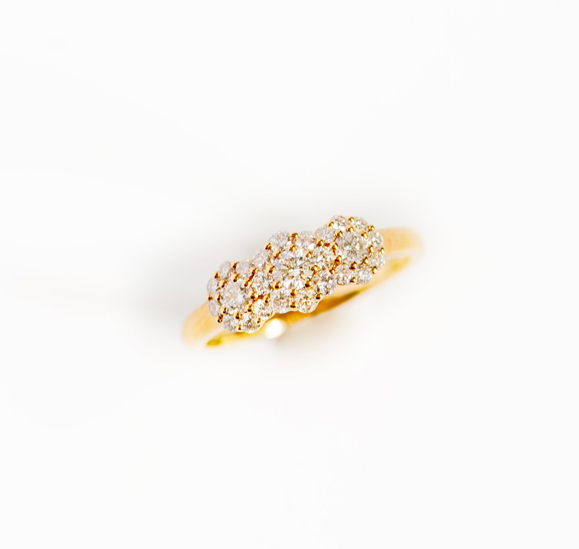 Yellow gold and diamond ring. Diamonds are in clusters that look like flowers. Three flowers. Dainty, vintage, timeless.