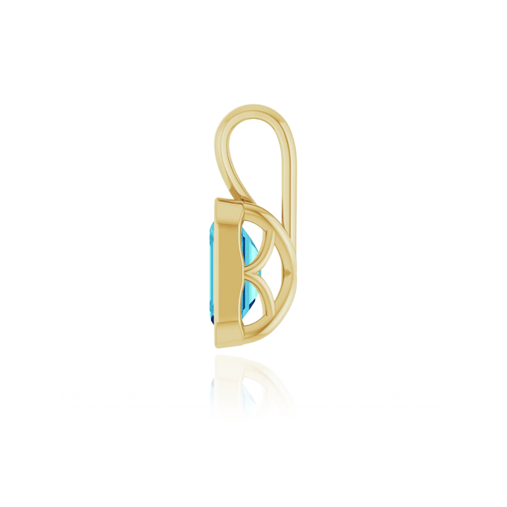 Gold charm pendant with a blue gemstone on a white background