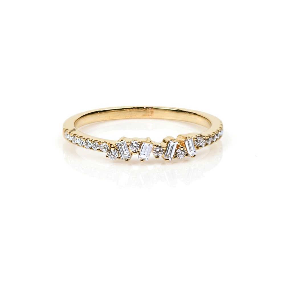 Dainty gold band with baguette and round diamond accents on a white background