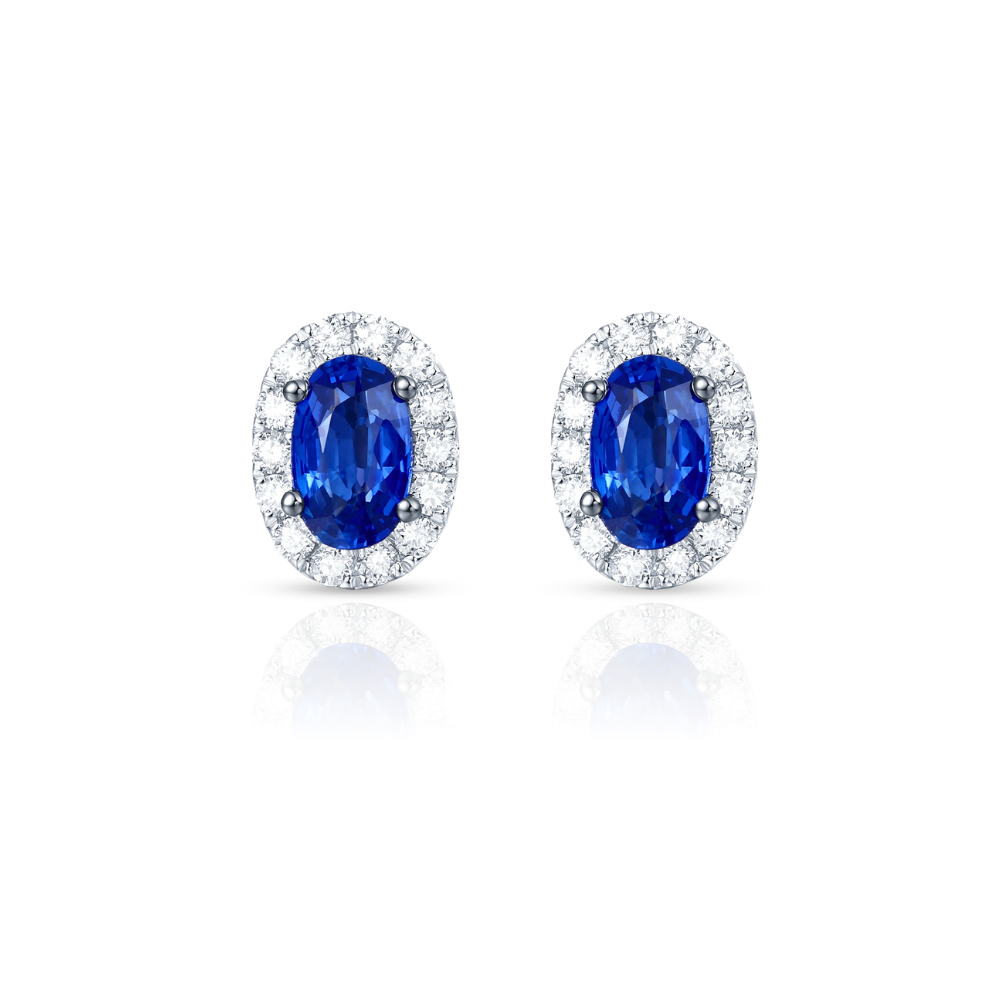 Pair of sapphire earrings with diamond accents on a white background