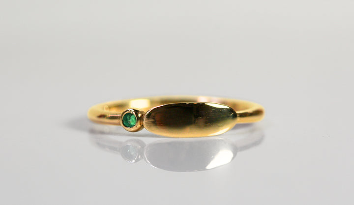 Yellow gold ring - wide oval signet ring. Round emerald is bezel set next to the signet. Face of ring could be engraved!