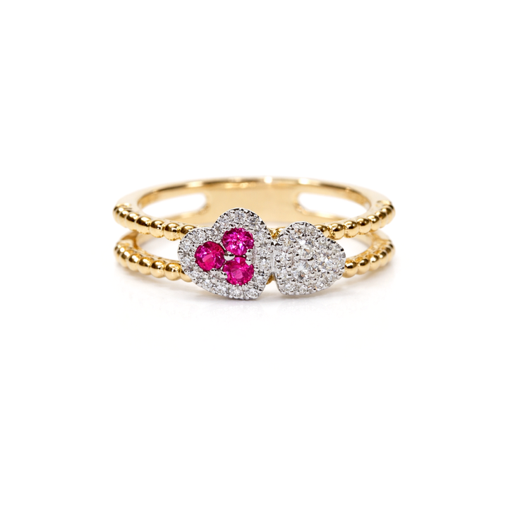Gold ring with two heart-shaped motifs with rubies and diamonds on a white background