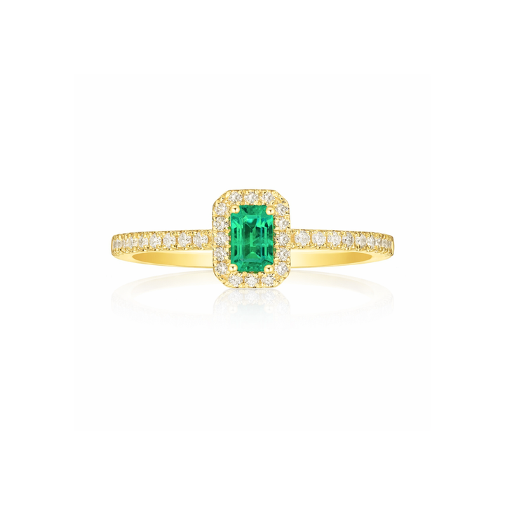 Gold ring with a green emerald and diamond accents on a white background