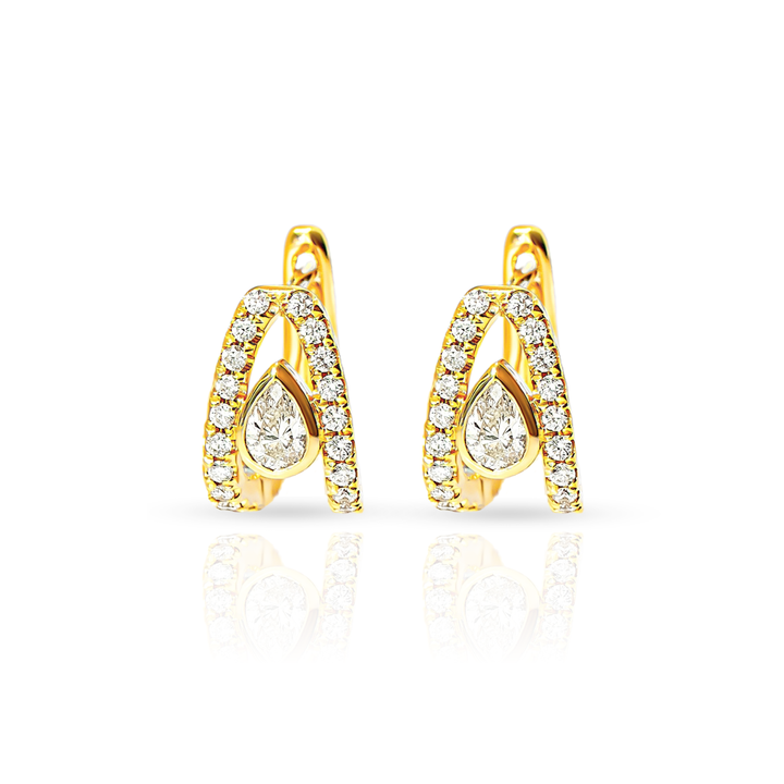 A pair of gold huggie hoop earrings accented with small pavé diamonds and a central pear-cut diamond, shown on a clean white background with a soft reflection below.